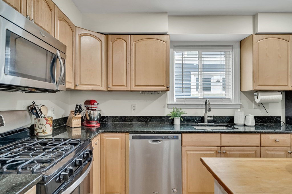 63-65 Brookley Road, Unit 1 Boston, MA 02130 - Photo 8 of 20 a kitchen with stainless steel appliances granite countertop a sink stove and microwave