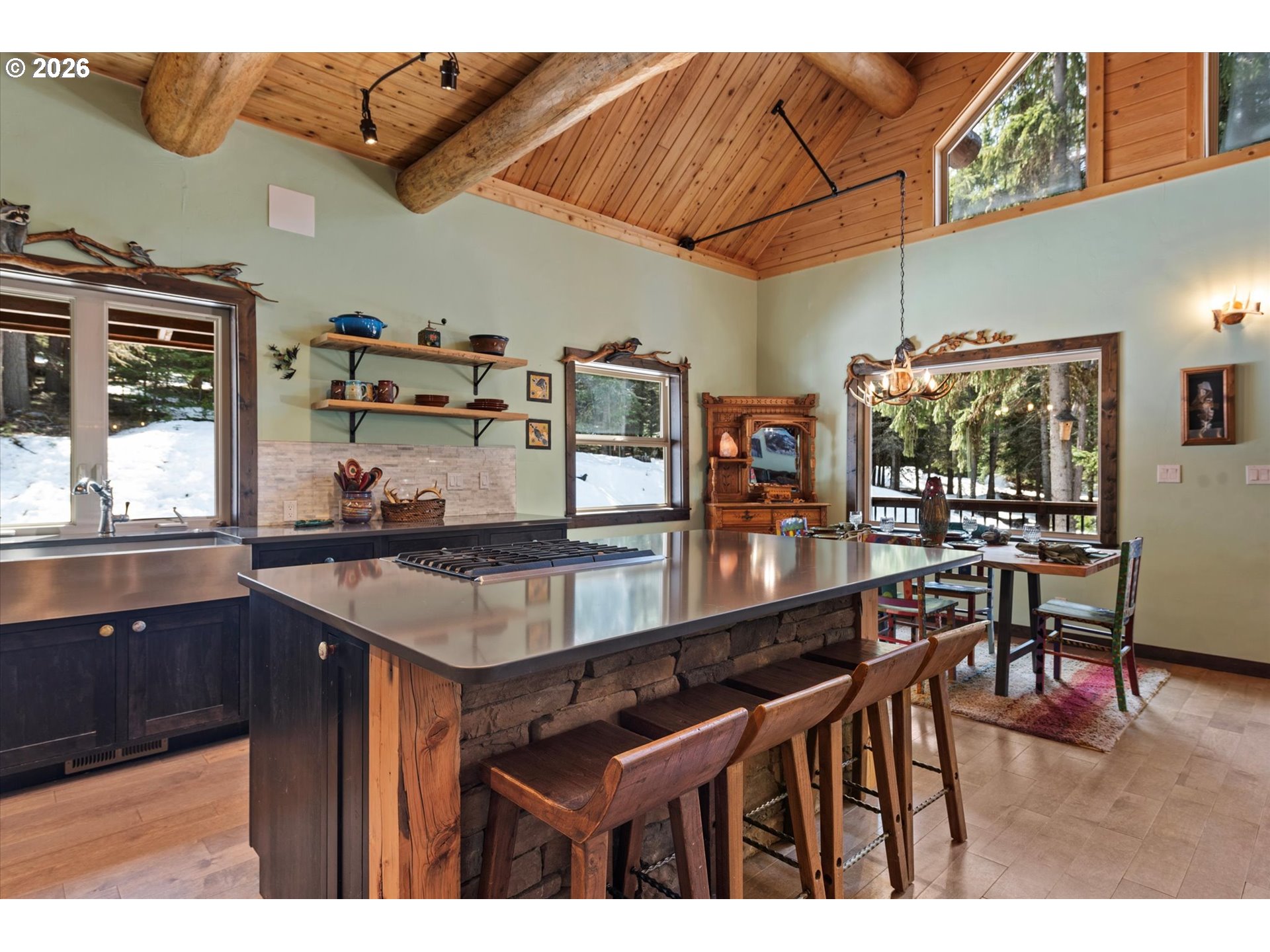 60989 Old Ski Run Road Joseph, OR 97846 - Photo 6 of 46 a kitchen with stainless steel appliances kitchen island granite countertop a table chairs in it and wooden floor