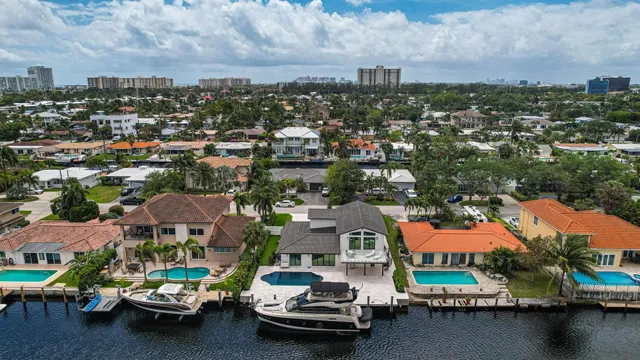 an aerial view of a city with lots of residential buildings ocean and mountain view in back
