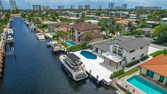 an aerial view of residential houses with outdoor space and ocean view