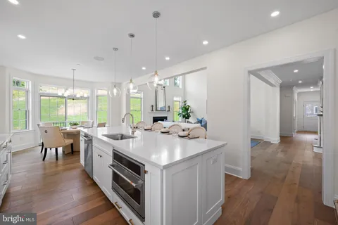 a kitchen with a sink and wooden floor