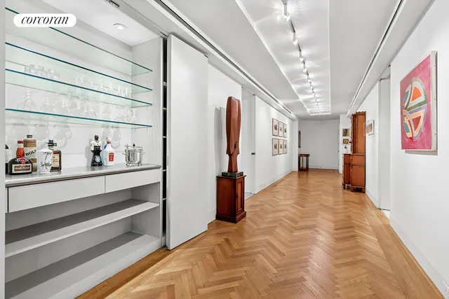 a view of a hallway with wooden floor and furniture