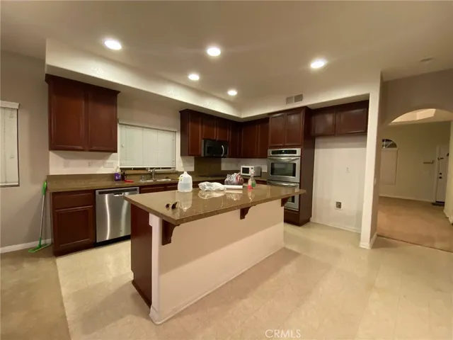 a kitchen with stainless steel appliances granite countertop a refrigerator stove a sink and a oven