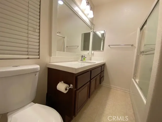 a bathroom with a sink a toilet a mirror and shower
