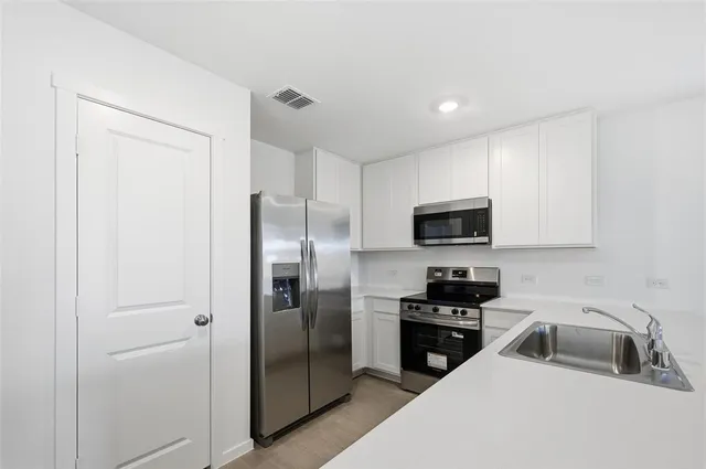 a kitchen with a refrigerator and a sink