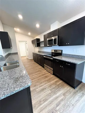 a kitchen with stainless steel appliances granite countertop a sink and a stove
