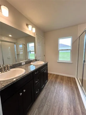 a bathroom with a granite countertop double vanity sink and a mirror