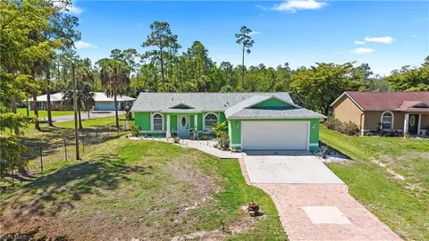 a house with green field in front of it