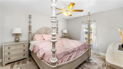 a bedroom with a bed a chandelier and a window