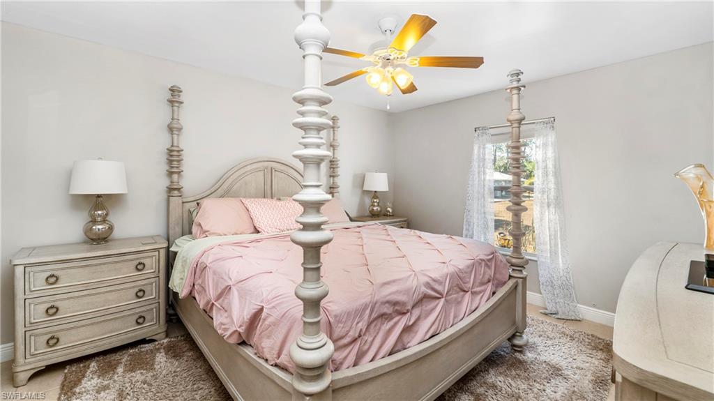 3340 2nd Avenue Southeast Naples, FL 34117 - Photo 11 of 24 a bedroom with a bed a chandelier and a window