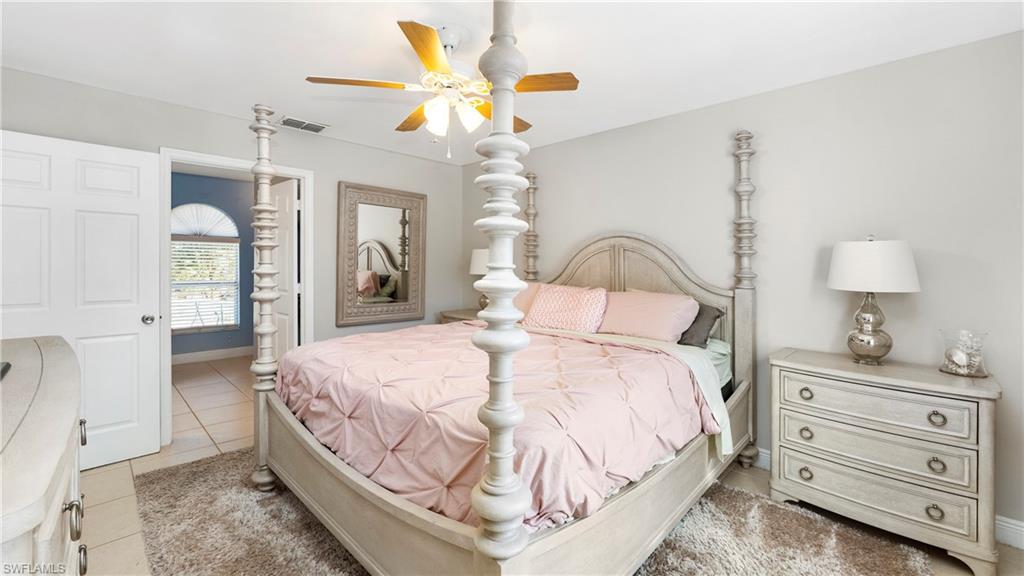 3340 2nd Avenue Southeast Naples, FL 34117 - Photo 12 of 24 a bedroom with a bed a chandelier and a dresser