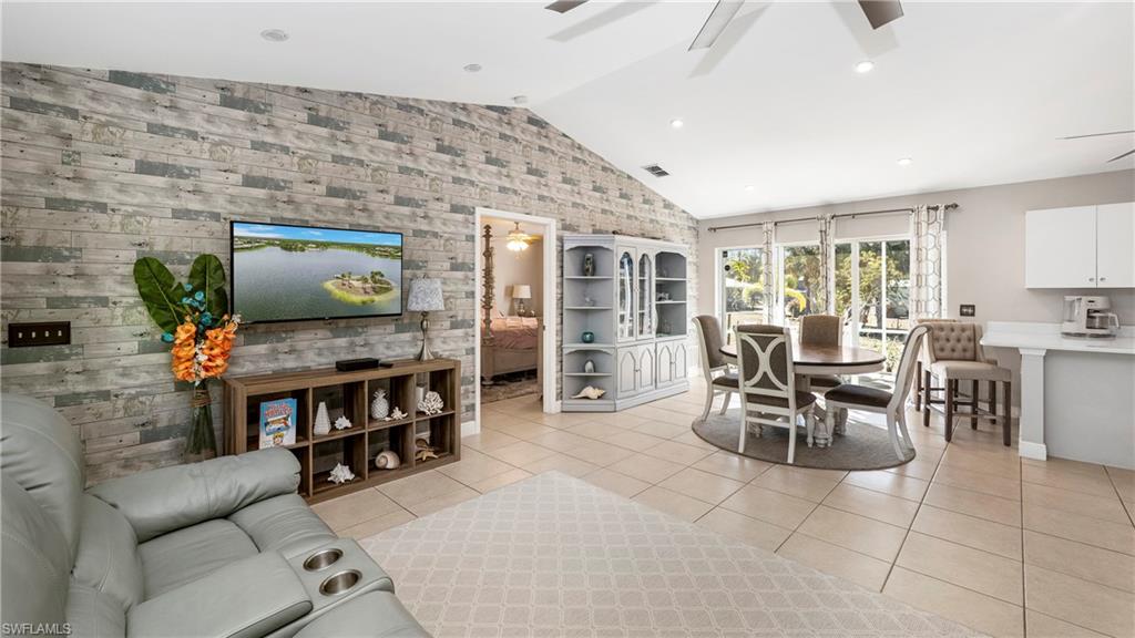 3340 2nd Avenue Southeast Naples, FL 34117 - Photo 7 of 24 a living room with furniture a dining table and a flat screen tv