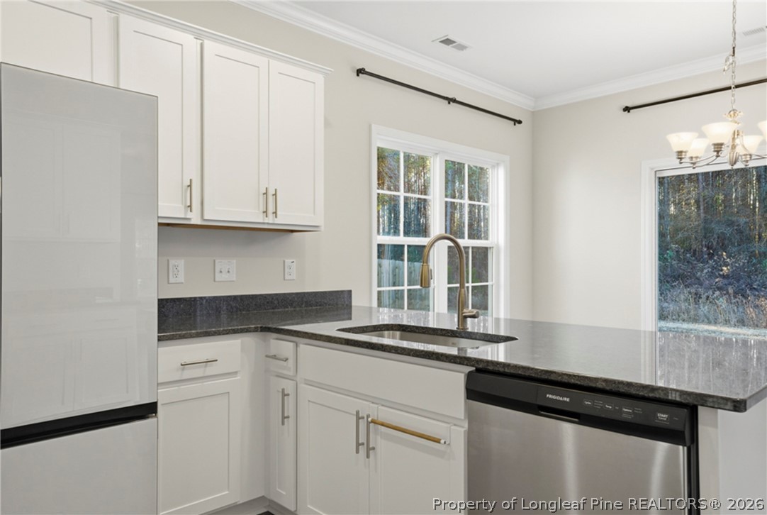 106 Knotts Berry Road Bunnlevel, NC 28323 - Photo 19 of 50 a kitchen with granite countertop white cabinets and black appliances