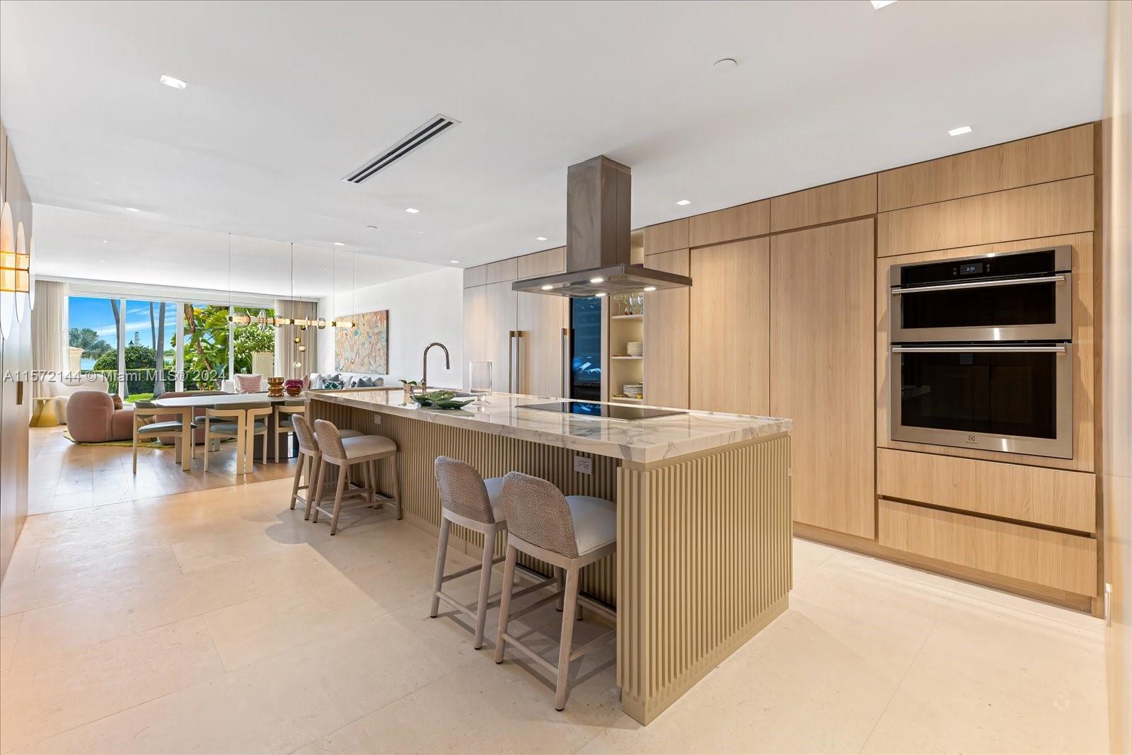 2113 Fisher Island Drive, Unit 2113 Miami Beach, FL 33109 - Photo 11 of 49 a kitchen with a table chairs and a refrigerator