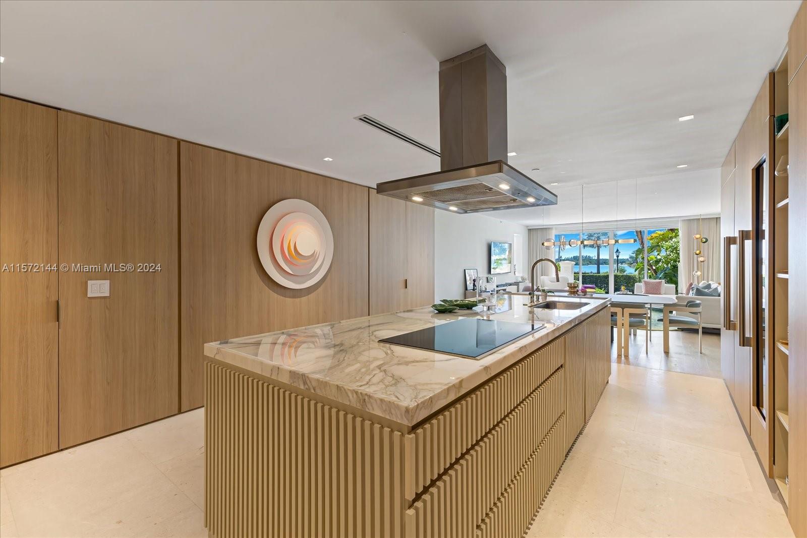 2113 Fisher Island Drive, Unit 2113 Miami Beach, FL 33109 - Photo 12 of 49 a large kitchen with a large window and stainless steel appliances