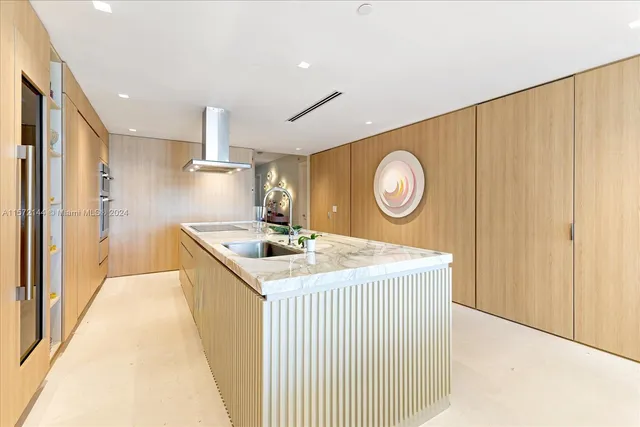 a kitchen with a sink a clock and cabinets