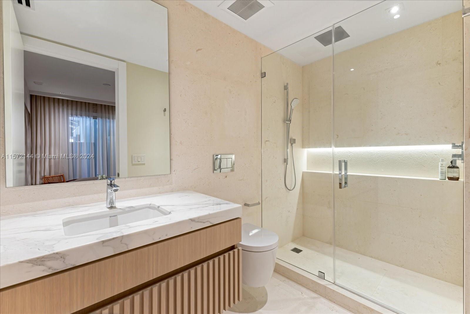 2113 Fisher Island Drive, Unit 2113 Miami Beach, FL 33109 - Photo 29 of 49 a bathroom with a sink toilet a mirror and shower