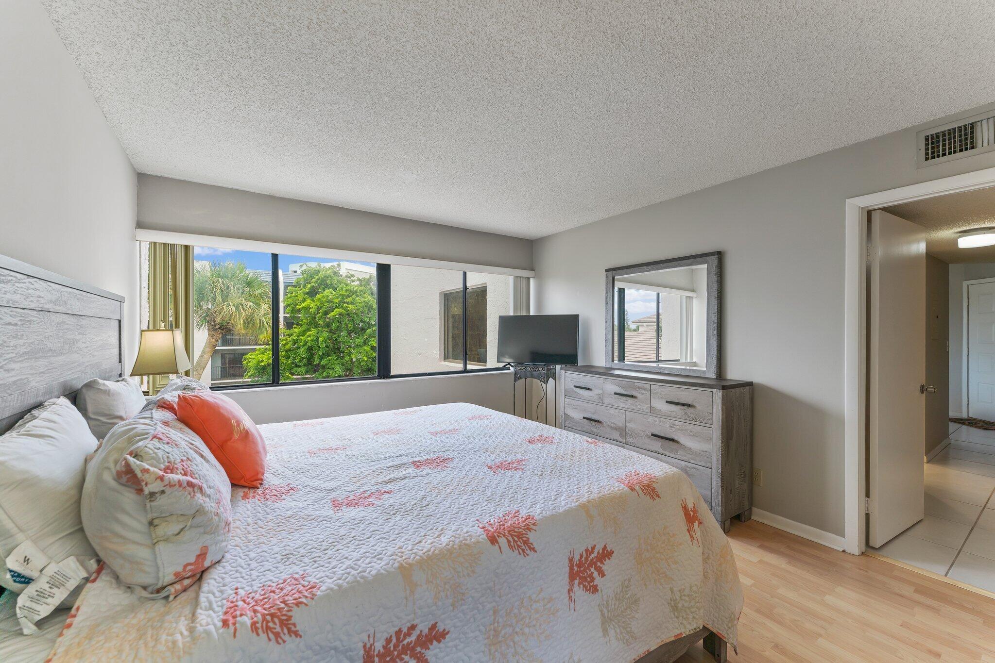 1605 Highway 1, Unit D301 Jupiter, FL 33477 - Photo 26 of 46 a bedroom with a large bed and a large window