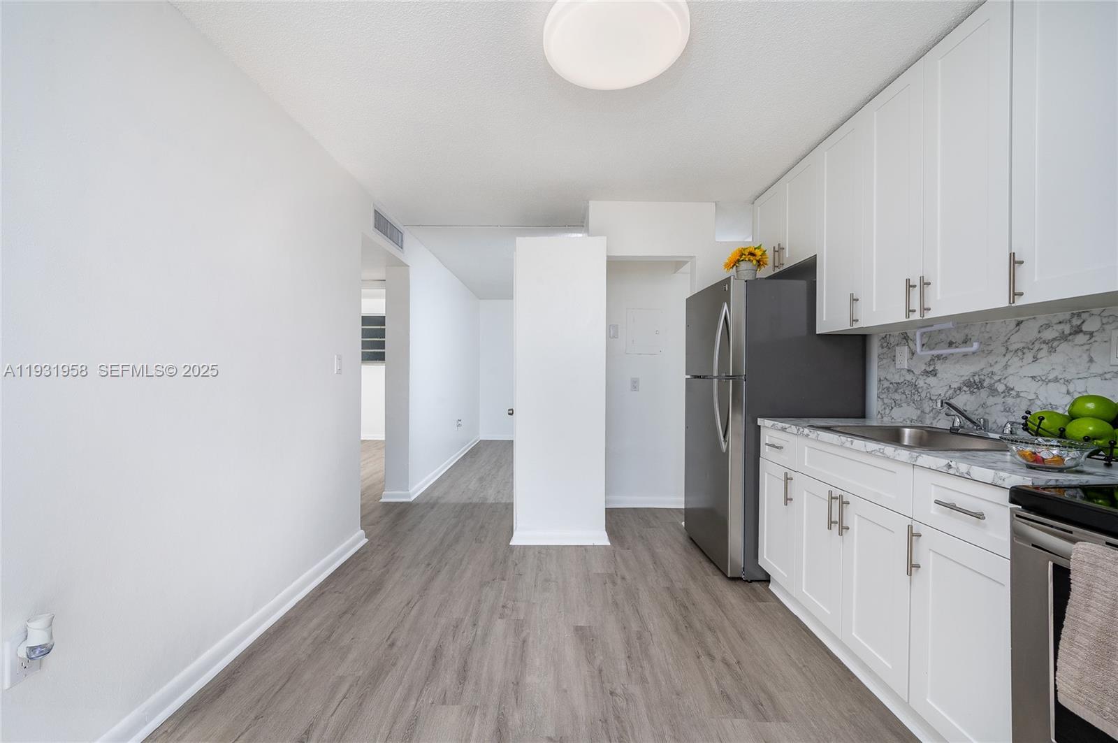 444 Southwest 27th Avenue, Unit 37 Miami, FL 33135 - Photo 5 of 18 a kitchen with a refrigerator a sink and wooden floor