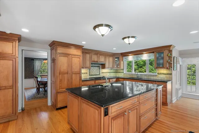 a kitchen with granite countertop a sink appliances and wooden floor
