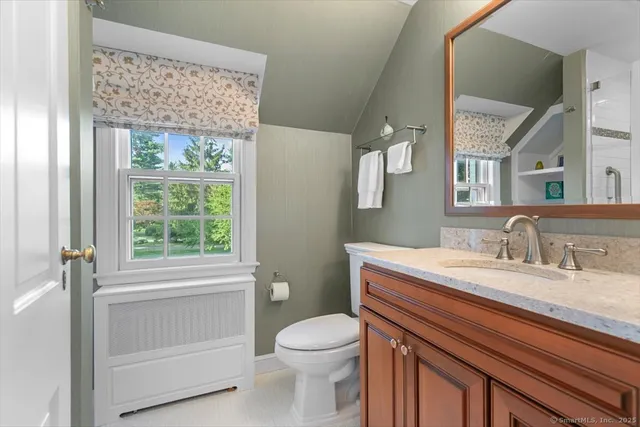 a bathroom with a sink a toilet and a window