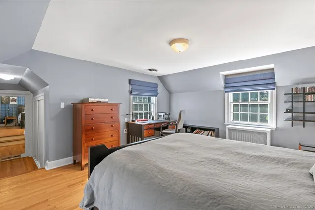 a bedroom with a bed and a large window