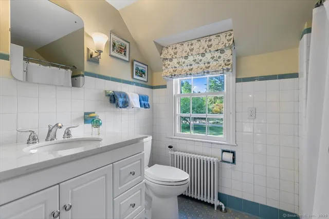 a bathroom with a sink a toilet and a window