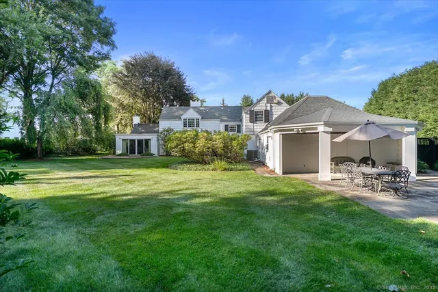 a view of a house with backyard and sitting area