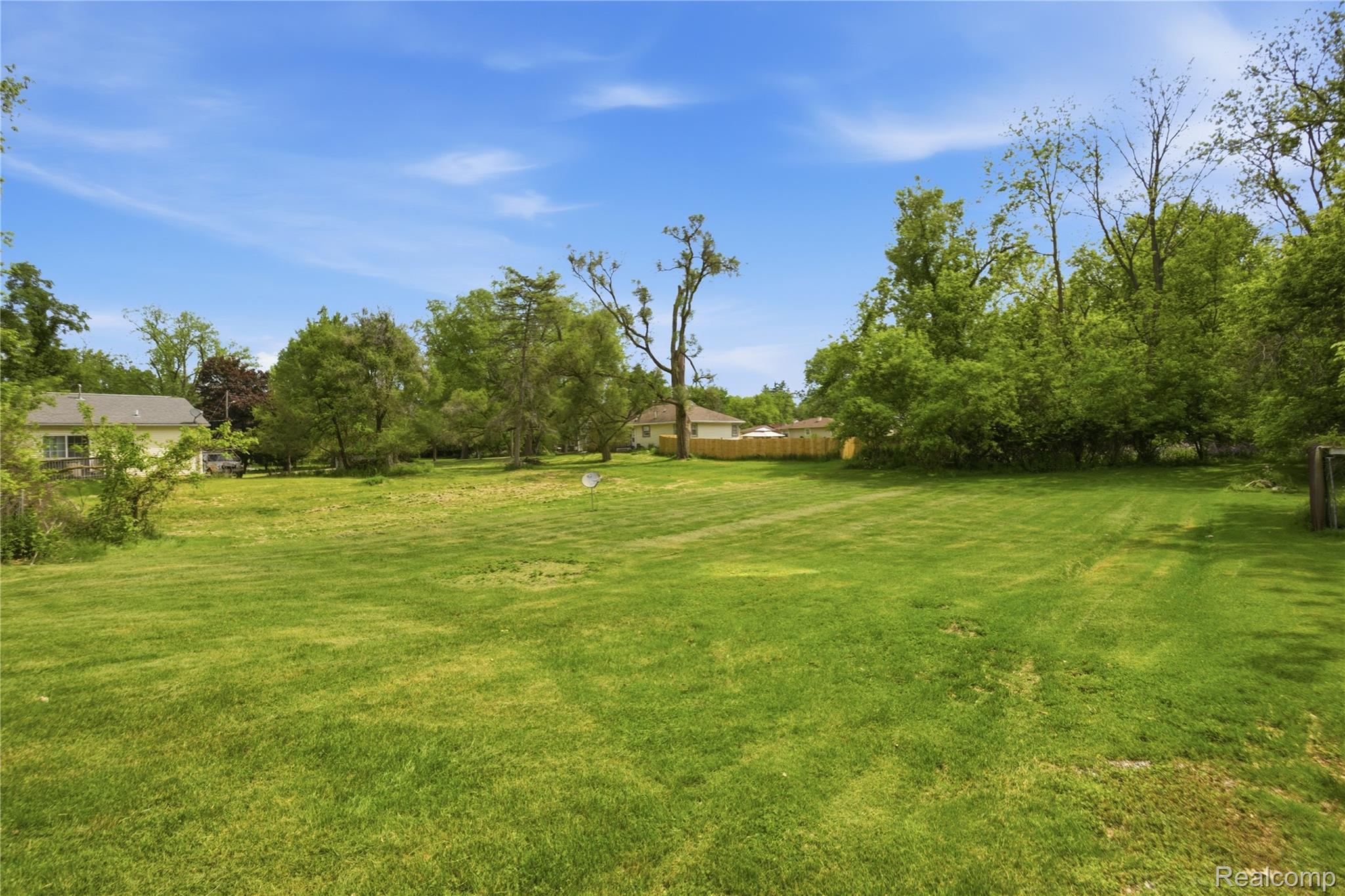 2705 Glendale Road Jackson, MI 49203 - Photo 46 of 57 Expansive green lawn with mature trees and a partial wood fence