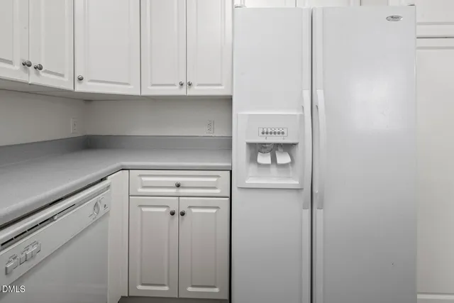 a kitchen with cabinets appliances a sink and a window