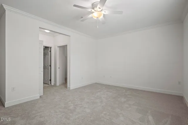 an empty room with windows and chandelier fan