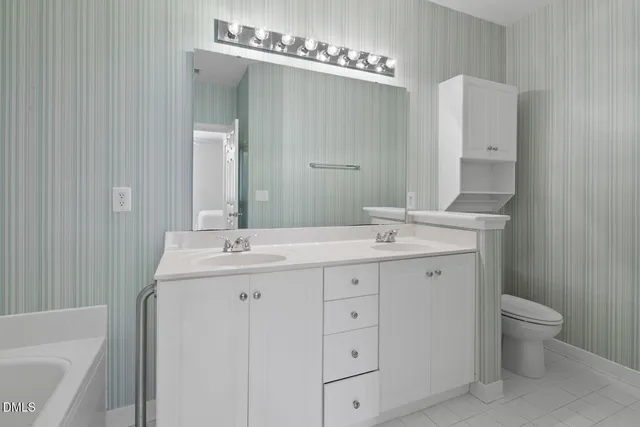 a spacious bathroom with a double vanity sink a large mirror and shower