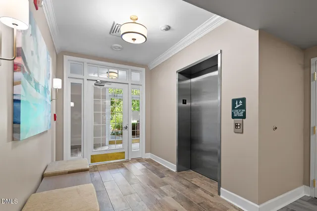 a view of an empty room with wooden floor and windows