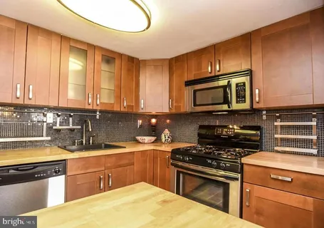 a kitchen with stainless steel appliances a stove sink microwave and cabinets