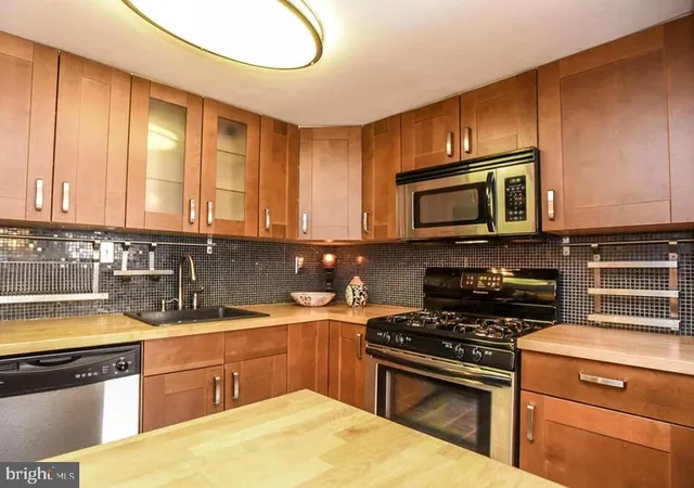 a kitchen with stainless steel appliances a stove sink microwave and cabinets