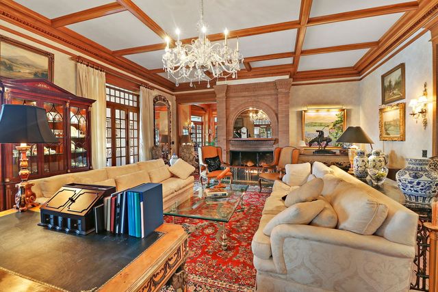 a living room with furniture a chandelier and a dining table