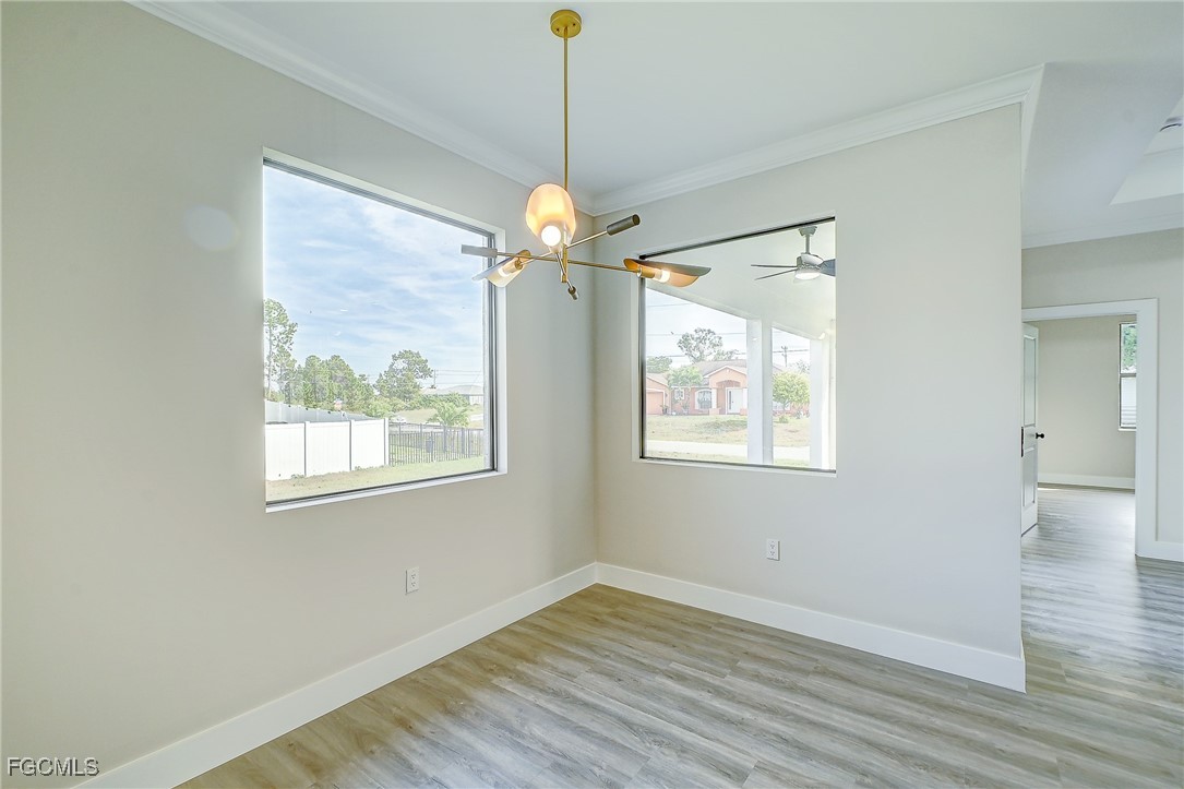 3108 20th Street Southwest Lehigh Acres, FL 33976 - Photo 12 of 36 a view of an empty room with wooden floor and a window