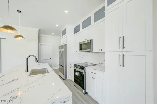 a kitchen with stainless steel appliances white cabinets and a refrigerator