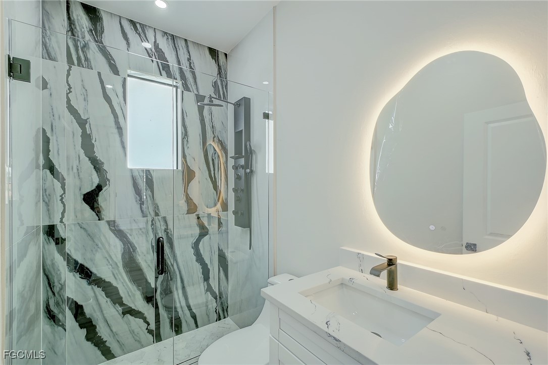 3108 20th Street Southwest Lehigh Acres, FL 33976 - Photo 22 of 36 a bathroom with a sink a toilet and a mirror