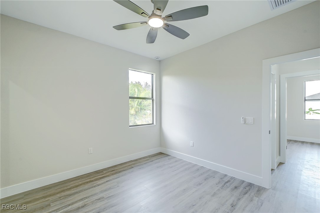 3108 20th Street Southwest Lehigh Acres, FL 33976 - Photo 23 of 36 wooden floor in an empty room with a window