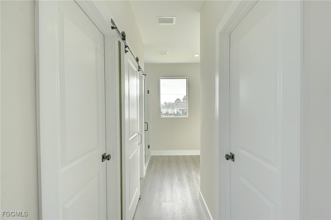 3108 20th Street Southwest Lehigh Acres, FL 33976 - Photo 25 of 36 a view of a hallway with wooden floor