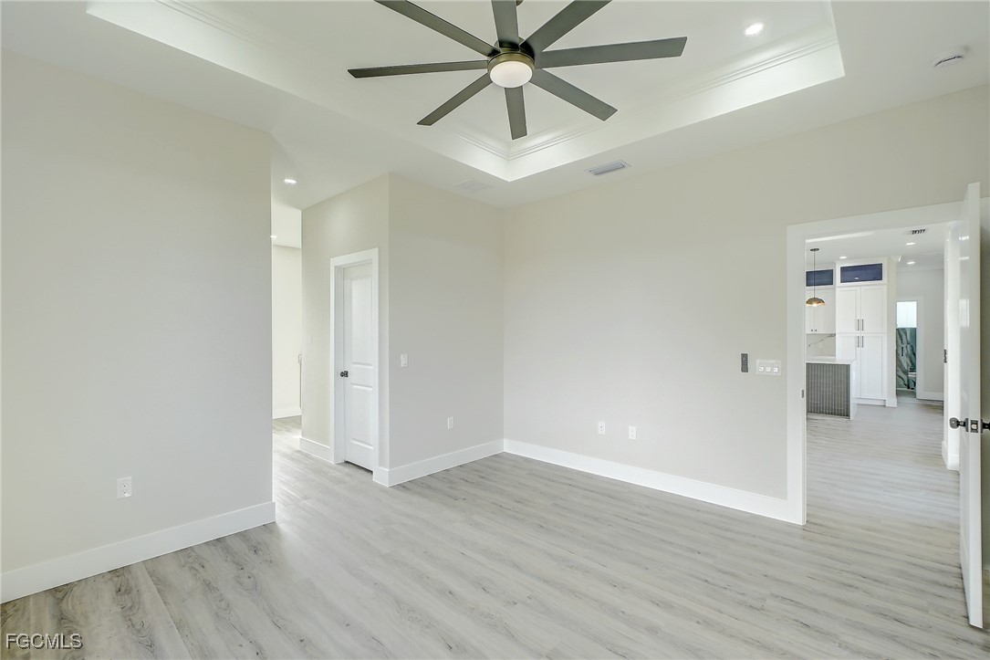 3108 20th Street Southwest Lehigh Acres, FL 33976 - Photo 26 of 36 an empty room with wooden floor and ceiling fan