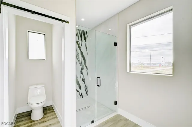 a bathroom with a toilet and a shower