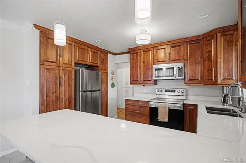 a kitchen with stainless steel appliances granite countertop a refrigerator sink and stove