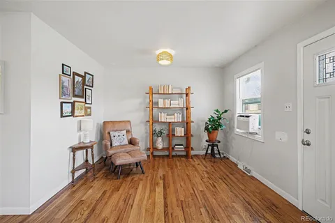 a view of a living room filled with furniture and wooden floor
