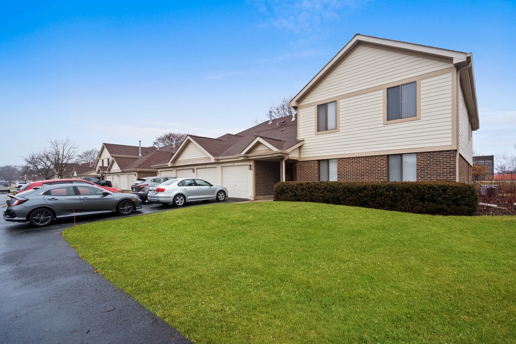 918 East Kings Row, Unit 1 Palatine, IL 60074 - Photo 1 of 36 a front view of a house with a garden and yard