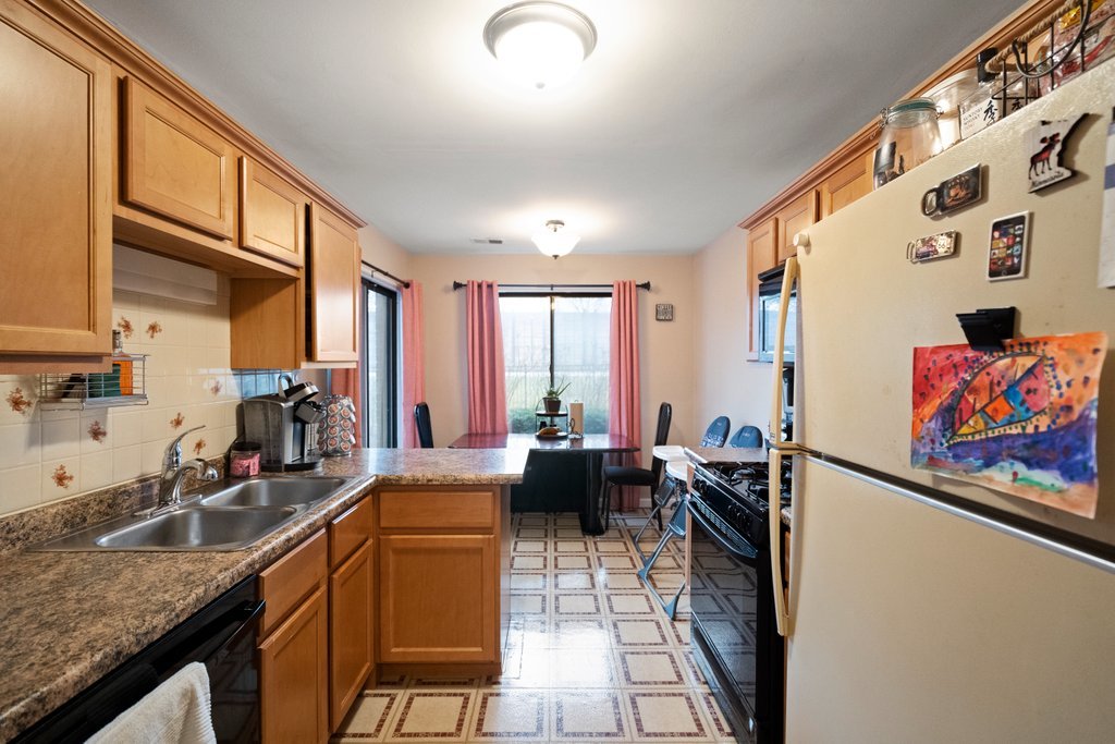 918 East Kings Row, Unit 1 Palatine, IL 60074 - Photo 18 of 36 a kitchen with stainless steel appliances granite countertop sink stove and large window