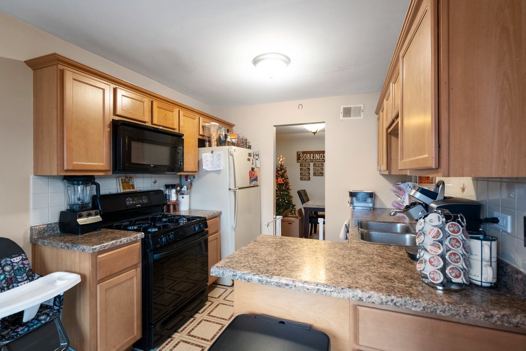 918 East Kings Row, Unit 1 Palatine, IL 60074 - Photo 21 of 36 a kitchen with stainless steel appliances granite countertop a sink stove and microwave