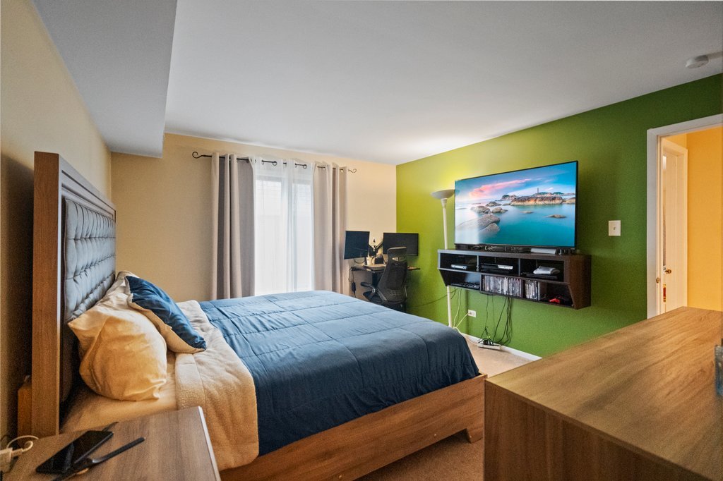 918 East Kings Row, Unit 1 Palatine, IL 60074 - Photo 27 of 36 a bedroom with a bed and a flat screen tv