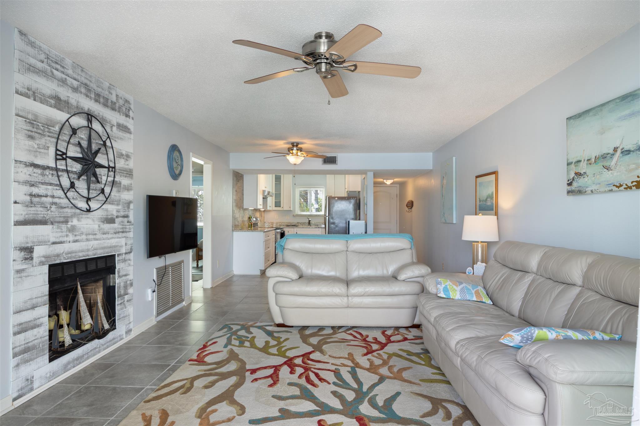 14100 River Road, Unit 228B Pensacola, FL 32507 - Photo 25 of 41 a living room with furniture a flat screen tv and a fireplace
